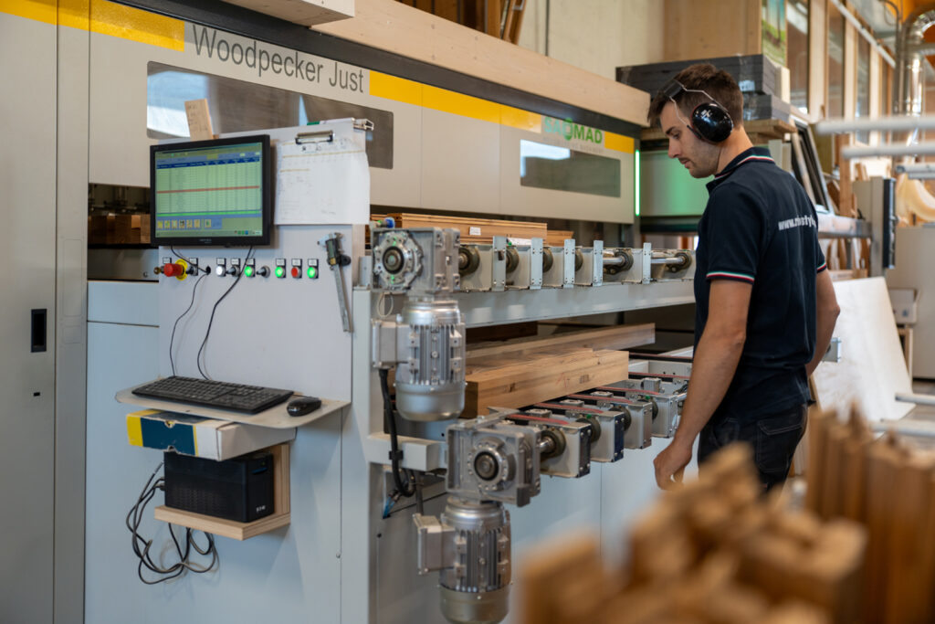 Artigiano che utilizza un macchinario per rifinire il legno